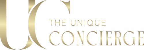 A gold and white logo of &quot;The Unique Concierge&quot; with large stylized letters &quot;UC&quot; and smaller text reading &quot;THE UNIQUE CONCIERGE&quot; to the right. The design is sleek and elegant, reflecting the premium concierge services akin to Emirates&apos; standards in excellence.